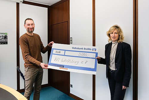 Stephan Ehlers, Geschäftsführer des VfL Wolfsburg e.V., nimmt den Spendenscheck von Claudia Kayser, Leiterin der Direktion Wolfsburg der Volksbank BraWo, entgegen. Foto: Volksbank BraWo / Cagla Canidar / KURT Media