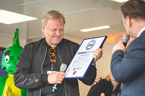 Jürgen Brinkmann, Vorstandsvorsitzender Volksbank BRAWO/BRAWO GROUP und Initiator von United Kids Foundations, nahm 2019 die Weltrekord-Urkunde, offiziell bestätigt vom Rekord-Institut für Deutschland, entgegen. Bildquelle: AUSDRUCKSLOS Jürgen Brinkmann, Vorstandsvorsitzender Volksbank BRAWO/BRAWO GROUP und Initiator von United Kids Foundations, nahm 2019 die Weltrekord-Urkunde, offiziell bestätigt vom Rekord-Institut für Deutschland, entgegen. Bildquelle: AUSDRUCKSLOS