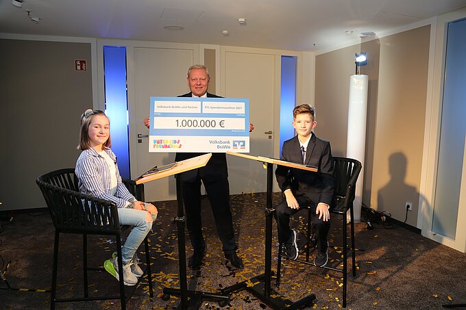Jürgen Brinkmann, Vorstandsvorsitzender der Volksbank BraWo, übergibt mit den Kindern Maja und Leander beim RTL Spendenmarathon eine Spende in Höhe von 1.000.000 Euro an „Stiftung RTL - Wir helfen Kindern e.V.". Foto: Volksbank BraWo Jürgen Brinkmann, Vorstandsvorsitzender der Volksbank BraWo, übergibt mit den Kindern Maja und Leander beim RTL Spendenmarathon eine Spende in Höhe von 1.000.000 Euro an „Stiftung RTL - Wir helfen Kindern e.V.". Foto: Volksbank BraWo
