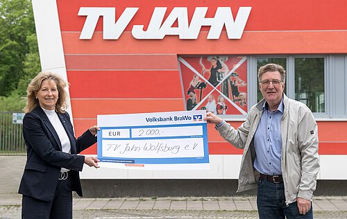 Claudia Kayser, Leiterin der Direktion Wolfsburg der Volksbank BraWo, übergibt die Spende symbolisch an Dirk Räke-Maresté, Geschäftsführer des TV Jahn Wolfsburg. Foto: Volksbank BraWo