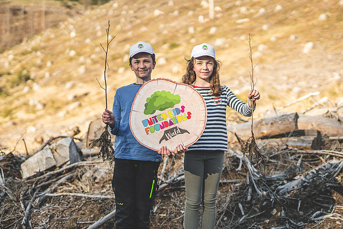 Linda und Lennox Beese präsentieren Schößlinge, die im United Kids Foundations Wald gepflanzt werden.