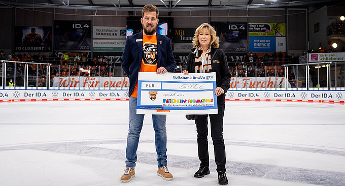 Simon Drühmel, Leiter Sales der Grizzlys Wolfsburg, übergibt den symbolischen Spendenscheck des Charity-Spieltags über 5.000 Euro an Claudia Kayser, Leitung der Direktion Wolfsburg. Foto: City-Press GmbH Simon Drühmel, Leiter Sales der Grizzlys Wolfsburg, übergibt den symbolischen Spendenscheck des Charity-Spieltags über 5.000 Euro an Claudia Kayser, Leitung der Direktion Wolfsburg. Foto: City-Press GmbH