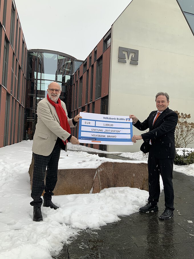 Detlef Tanke, Vorsitzender der Stiftung "ZeitSTIFTEN", nimmt die Spende über 1.000 Euro von Thomas Fast, Leiter der Direktion Gifhorn der Volksbank BraWo, entgegen. Foto: Volksbank BraWo