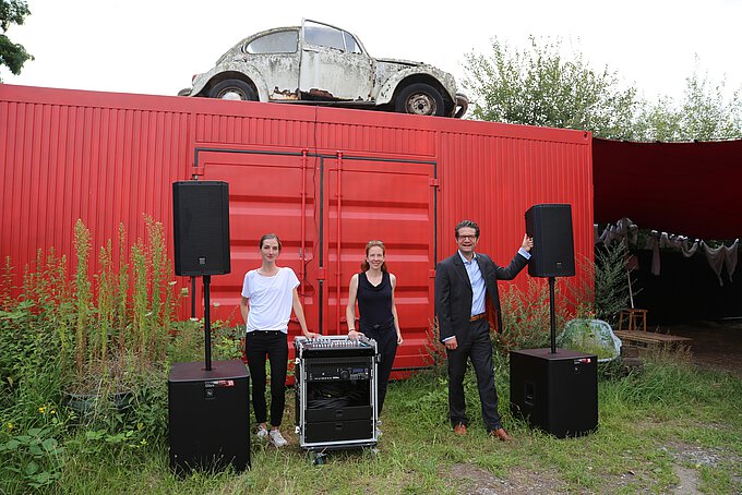 Schriftführerin Dr. Mareike Herbstreit (l.) und Henrike Wenzel (1. Vorsitzende Kunstverein DIE H_LLE e.V.) präsentieren die neue Musikanlage, die mit der Unterstützung der Volksbank BraWo, vertreten durch Carsten Ueberschär, angeschafft wurde.
