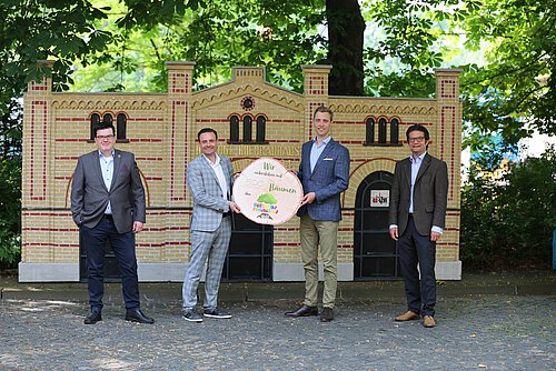 Alexander Arsene und Francesco Perricone, Geschäftsführer der Hofbrauhaus Wolters GmbH, übergeben symbolisch 500 Bäume für den United Kids Foundations Wald an Janis Meyerhof und Carsten Ueberschär. (v. li.) Foto: Volksbank BraWo