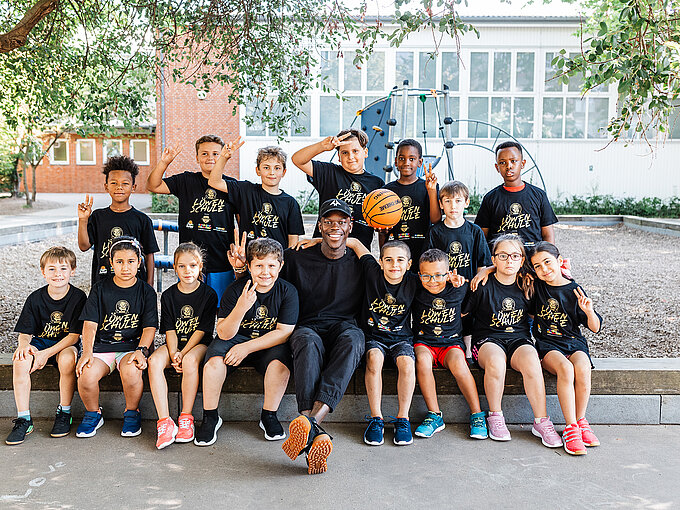 Dennis Schröder besuchte für den Projektauftakt von jump4future die Grundschule Diesterwegstraße, um den Schülerinnen und Schülern der neu gegründeten AG den Basketballsport näher zu bringen. Quelle: Volksbank BRAWO/Nina Stiller