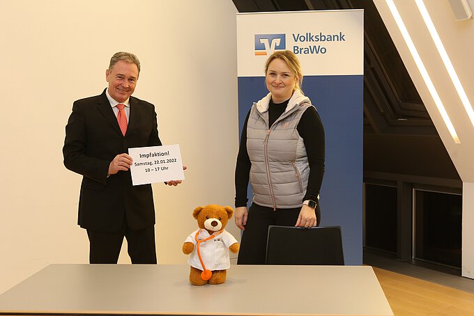 Ärztin Yvonne Trommer und Thomas Fast, gemeinsam mit "Dr. Bär", in den Räumlichkeiten der Gifhorner Hauptstelle Steinweg, die am 22. Januar vorübergehend zur Impfstation wird. Foto: Volksbank BraWo / KURT Media - Michael Uhmeyer