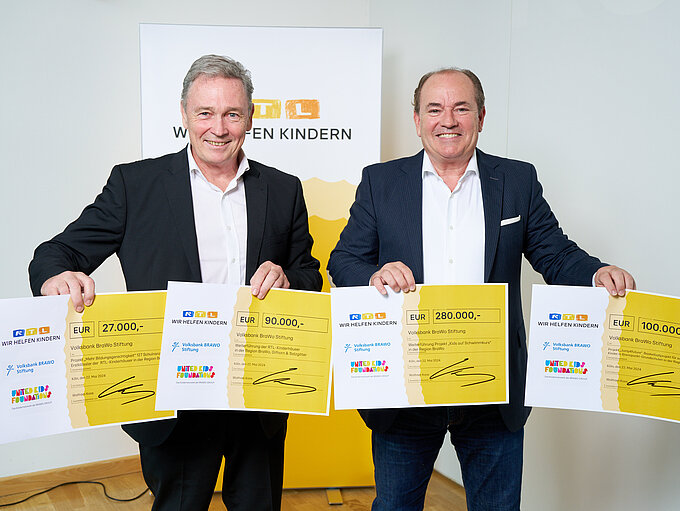 Thomas Fast (l.), Vorstandsvorsitzender der Volksbank BRAWO Stiftung, nahm die symbolischen Spendenschecks von Wolfram Kons, Vorstandsmitglied der "Stiftung RTL - Wir helfen Kindern e. V.", i. H. v. 470.000 Euro für Projekte in der BRAWO-Region entgegen.