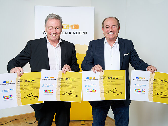 Thomas Fast (l.), Vorstandsvorsitzender der Volksbank BRAWO Stiftung, nahm die symbolischen Spendenschecks von Wolfram Kons, Vorstandsmitglied der "Stiftung RTL - Wir helfen Kindern e. V.", i. H. v. 470.000 Euro für Projekte in der BRAWO-Region entgegen.