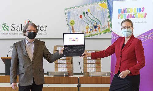 Salzgitters Sozialdezernent Dr. Dirk Härdrich nimmt 97 Laptops für das Homeschooling von Nicole Mölling, Botschafterin von United Kids Foundations und Leiterin der Direktion Salzgitter der Volksbank BraWo, entgegen. Foto: Volksbank BraWo