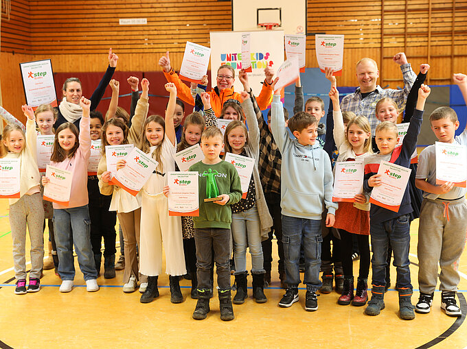 Die Kinder freuen sich über ihre Siegerurkunden, 250 Euro Preisgeld für die Klassenkasse und den Pokal.