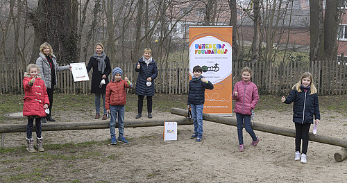 Claudia Kayser 2. v. links hinten) gratuliert jeweils einem Teil der im Wechselunterricht anwesenden Klasse 3n, Ulrike Svetlik und Ute Schönian zum Gewinn der 3. Bewegungschallenge. Foto: Volksbank BraWo