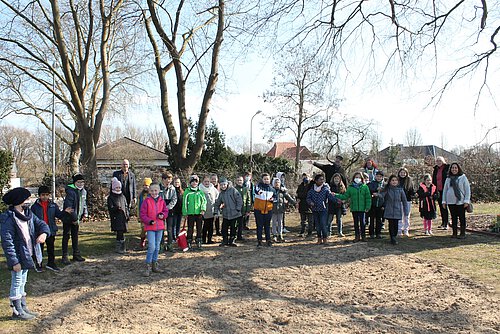 Zusammen mit (v.l.) Stefan Honrath, Pfarrer Hendrik Rust, Petra Zappe, Petra Burgdorf und Marina Bazan von der kath. Pfarrgemeinde Zu den Heiligen Engeln freuten sich die Kommunionkinder über ihren „Arbeitseinsatz“ auf dem Telgter Friedhof.