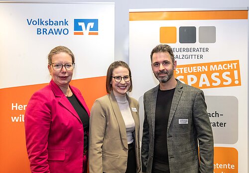 Drei Personen vor Bannern der Volksbank Brawo und Steuerberater Salzgitter lächeln in die Kamera.