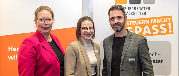 Drei Personen vor Bannern der Volksbank Brawo und Steuerberater Salzgitter lächeln in die Kamera.