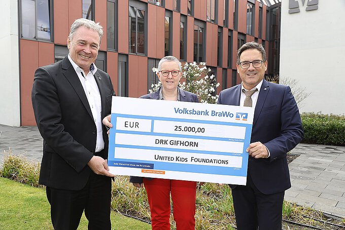 Thomas Fast (l.), Vorstandsvorsitzender der Volksbank BraWo Stiftung, überreicht einen symbolischen Scheck über 25.000 Euro an Silvia Smilowski und Sandro Pietrantoni (beide DRK Gifhorn). Foto: Volksbank BraWo / Michael Uhmeyer