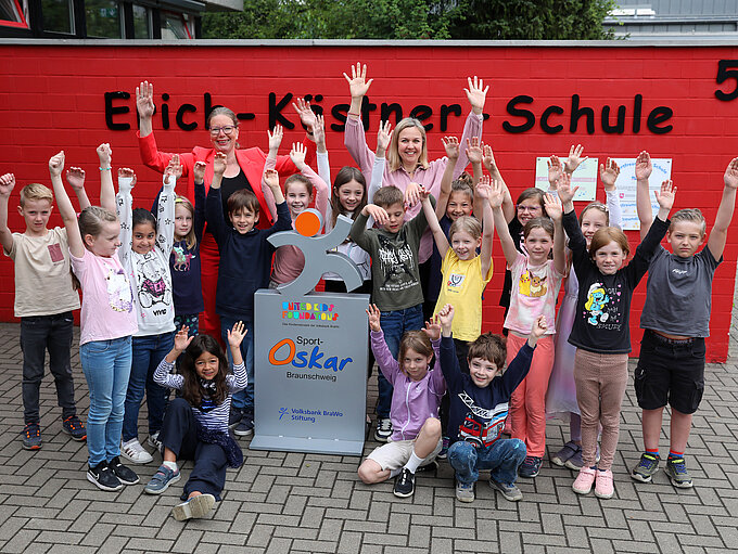Die Schülerinnen und Schüler der Erich-Kästner-Schule in Weddel freuen sich über die Sport-Oskar Trophäe, die ihnen von Nicole Mölling, Botschafterin von United Kids Foundations, übergeben wurde