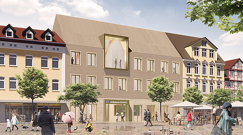 Straßenszene mit Fußgängern und einem modernen Gebäude mit Volksbank-Logo, umgeben von älteren Häusern.