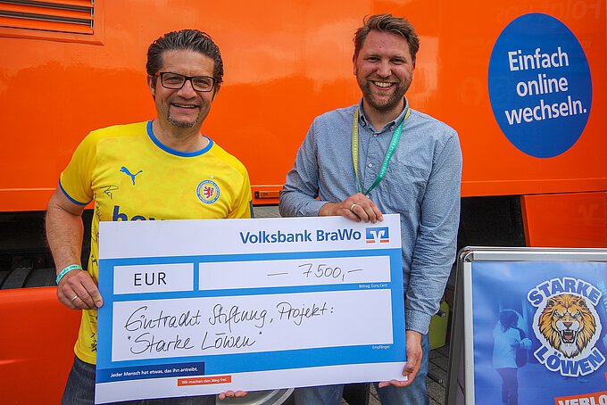 Carsten Ueberschär (l.), Leitung der Direktion Braunschweig der Volksbank BraWo, übergibt den symbolischen Spendenscheck an André Linder, geschäftsführender Vorstand der Eintracht Braunschweig Stiftung. Foto: Eintracht Braunschweig