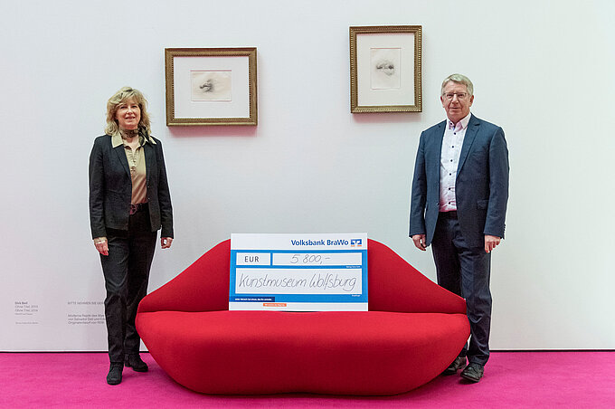 Otmar Böhmer, Geschäftsführer des Kunstmuseums Wolfsburg, nimmt eine Spende digitale Vermittlung der aktuellen Ausstellungen von Claudia Kayser, Leiterin der Direktion Wolfsburg der Volksbank BraWo, entgegen.