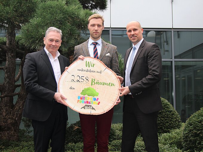 André Bonitzke (rechts) übergab im Beisein von Thomas Fast (links) symbolisch die 2.258 Bäume für den United Kids Foundations Wald an Dr. Janis Meyerhof (mitte) von den Niedersächsischen Landesforsten.