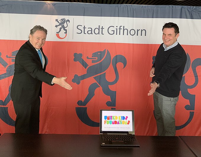 Thomas Fast (l.), Vorstandsvorsitzender der Volksbank BraWo Stiftung und Botschafter von United Kids Foundations, übergibt symbolisch einen Laptop an Gifhorns Bürgermeister Matthias Nerlich.