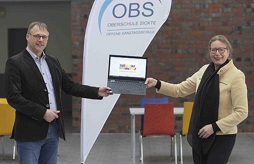 Nicole Mölling, Leiterin der Direktion Salzgitter/Sickte der Volksbank BraWo und Botschafterin von United Kids Foundations, übergibt die Laptops für das Homeschooling an Stefan Marken, Oberschulrektor der OBS Sickte. Foto: Volksbank BraWo