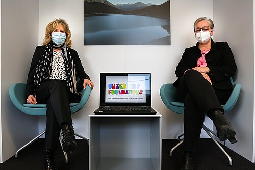 Claudia Kayser (l.), Botschafterin von United Kids Foundations und Leiterin der Direktion Wolfsburg, übergibt symbolisch einen Laptop an Iris Bothe, Stadträtin für Jugend, Bildung und Integration der Stadt Wolfsburg.