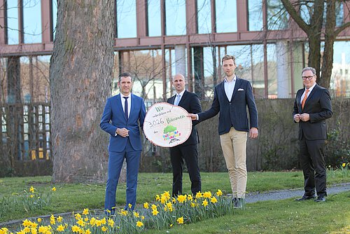 Patrick Pietschmann (l.), Vorstandsmitglied der Volksbank BraWo, übergibt symbolisch 3.026 Bäume an Janis Meyerhof von den Niedersächsischen Landesforsten (3. v. li.) im Beisein von André Bonitzke und Thomas Fast.