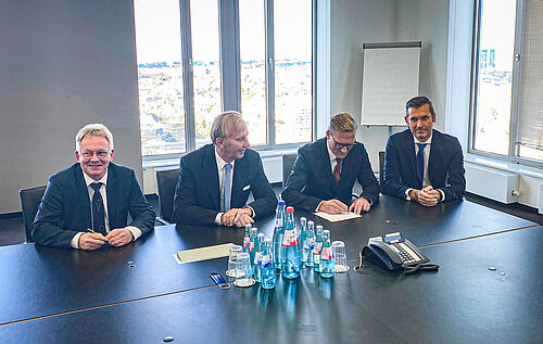 Auf dem Foto unterschreibt der VV der AOK, Herr Günter Wältermann. Rechts im Bild, Herr Patrick Pietschmann und links Herr Ralf Schierenböken, beide Mitglieder des Vorstands der Volksbank BraWo. Von FOM ist Prof. Reinhard Walter zu sehen. Foto: FOM