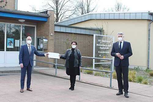 Stefan Honrath (l.) übergibt in seiner Funktion als United Kids Foundations-Botschafter symbolisch einen der insgesamt 112 Laptops an Yasemin Cirakbel, Schulleiterin der IGS Edemissen, und Henning Heiß, Erster Kreisrat. Foto: Volksbank BraWo